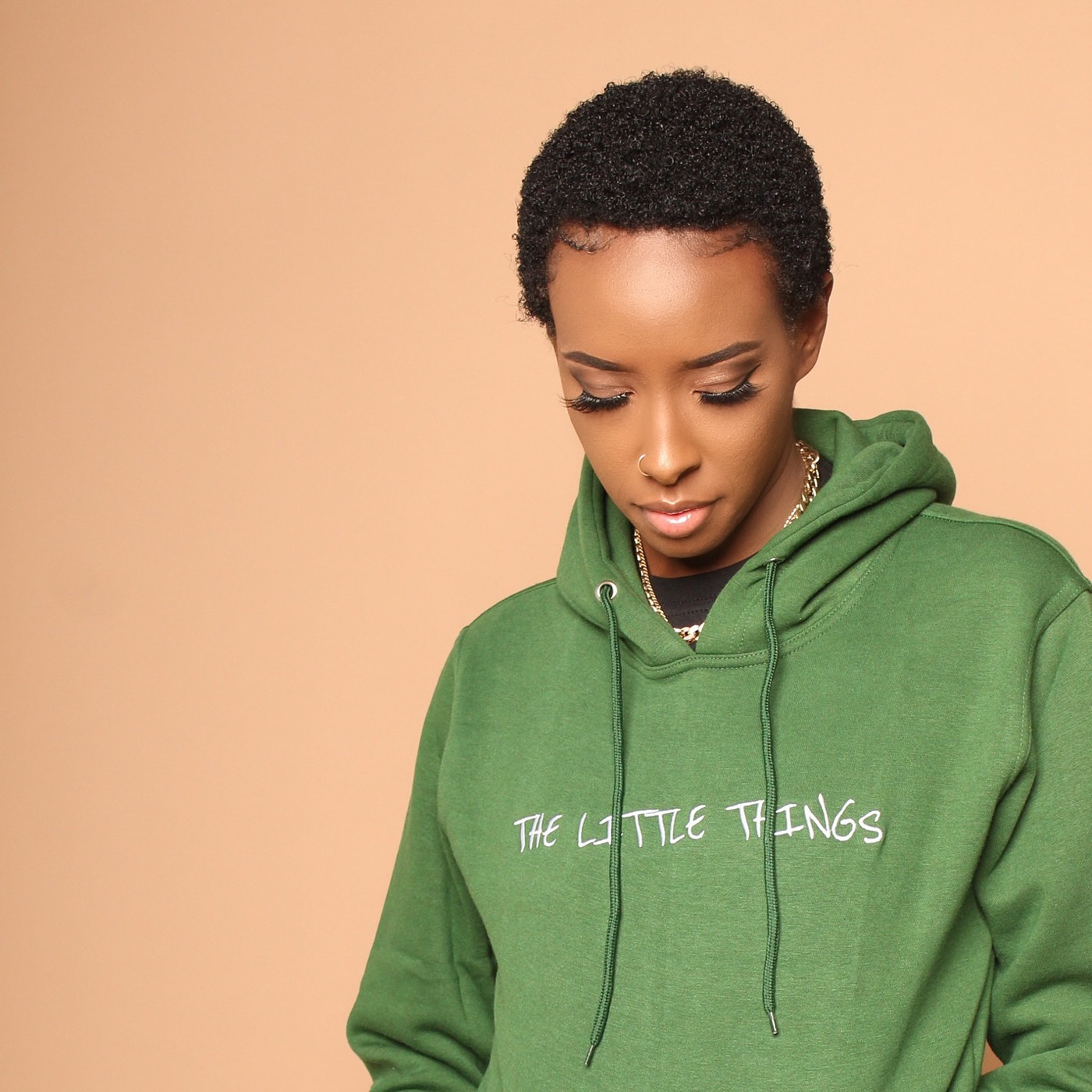 A woman in a green The Little Things hoodie